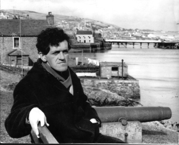 Stromness, Orkney Islands writer GMB sitting near the cannon in Stromness that once announced the arrival home of the Hudson's Bay Company ships to Orkney.