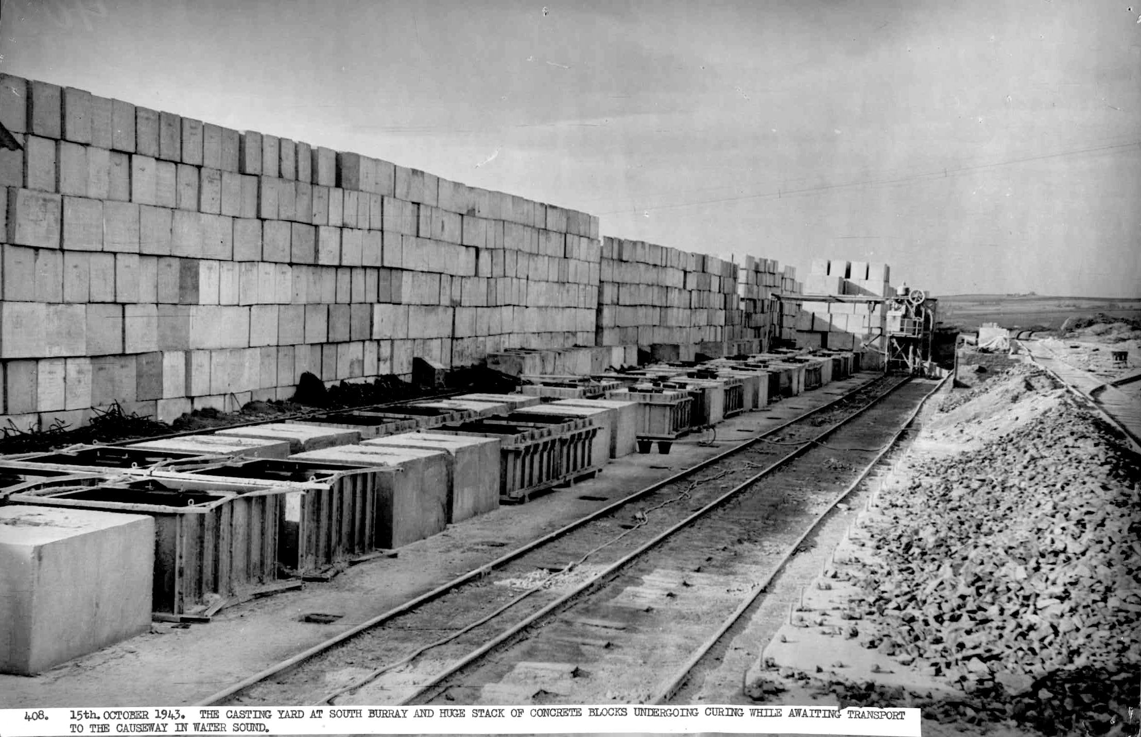The casting yard at South Burray with huge concrete blocks undergoing curing while awaiting transport to the causeway in Water Sound. WWII, Burray, Orkney Islands,Churchill Barriers: The casting yard at South Burray with huge concrete blocks undergoing curing while awaiting transport to the causeway in Water Sound. #Orkneyology.com
