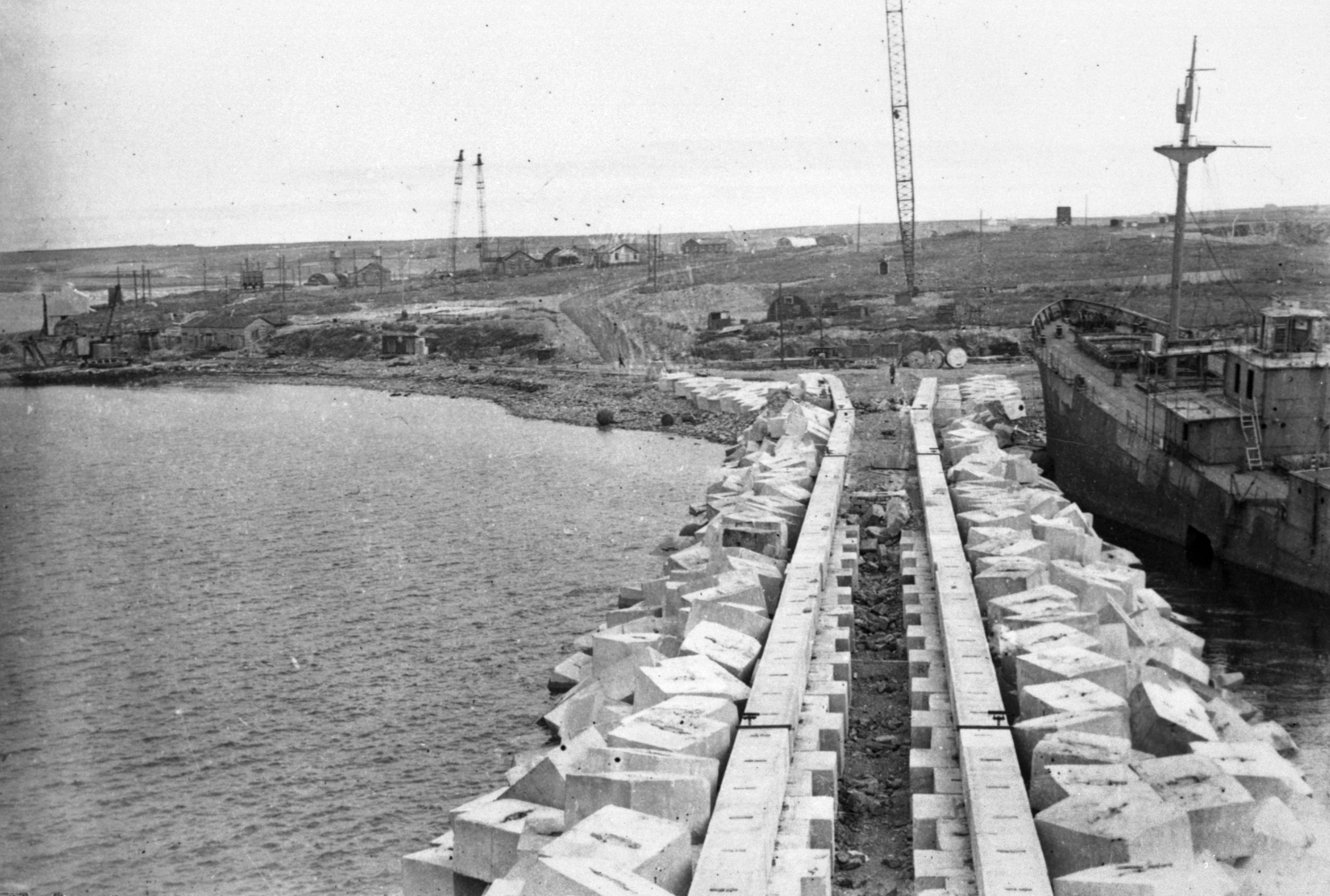 The construction of Barrier No 2, looking toward Lamb Holm. Notice the blockship Lycia, driven to shore under her own steam. POW's salvaged for materials there. The engine block is still visible. The Churchill Barriers being built by WWII Italian POWS and others in Scotland's Orkney Islands. www.Orkneyology.com