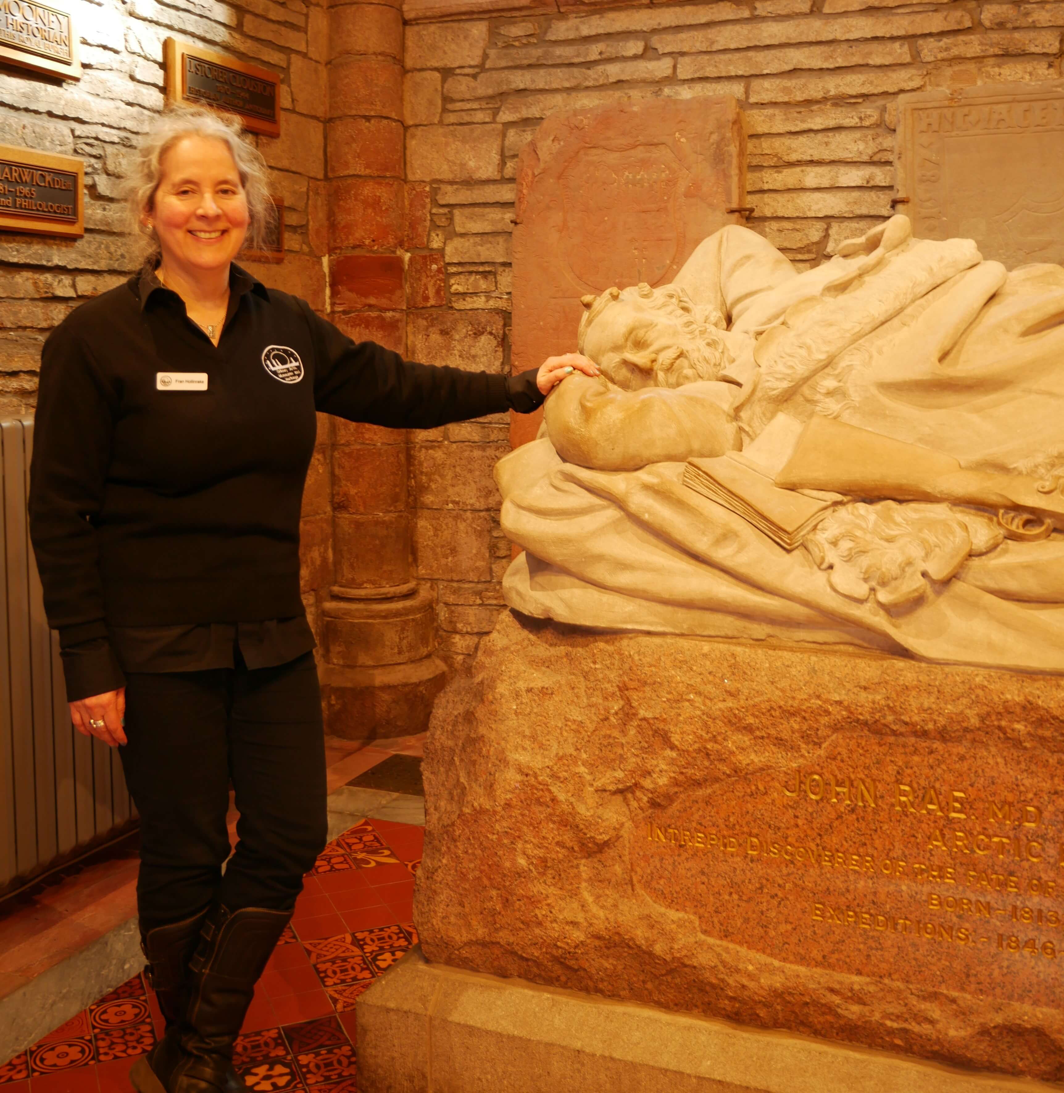 Fran Flett Hollinrake, custodian of St Magnus Cathedral in Kirkwall, Orkney stands beside the statue of a sleeping John Rae, arctic explorer, housed in the cathedral.