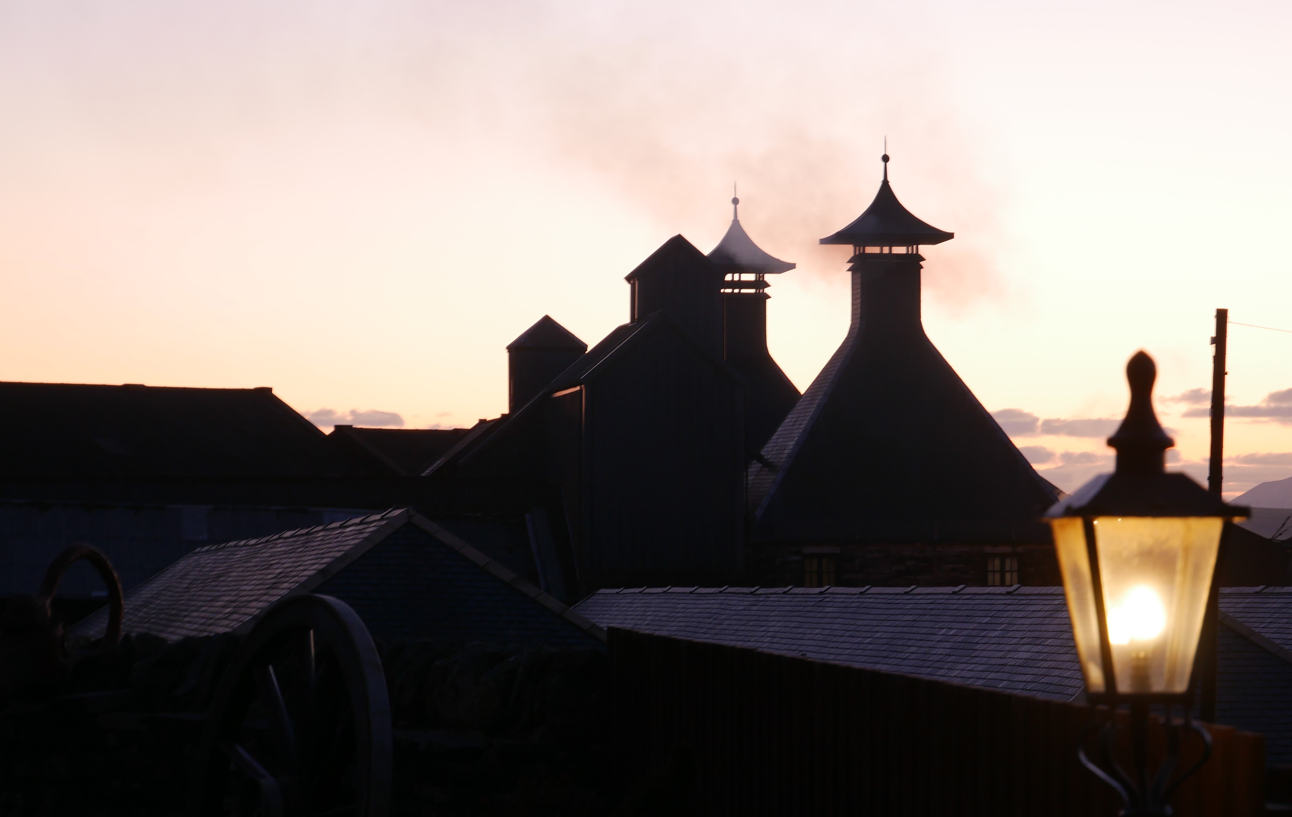 The smoking chimneys of Highland Park at dusk, Kirkwall, Orkney, Scotland, UK
