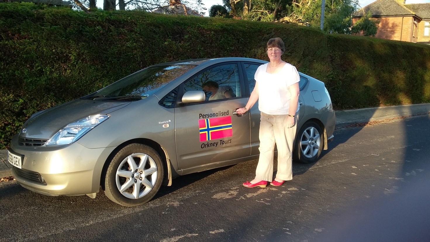 Jo Jones, Orkney Islands tour guide, with her Driver Guiding Vehicle – a Toyota Prius T4 Spirit Hybrid licensed to take up to 4 passengers. Local experts travel tips on Orkneyology.com