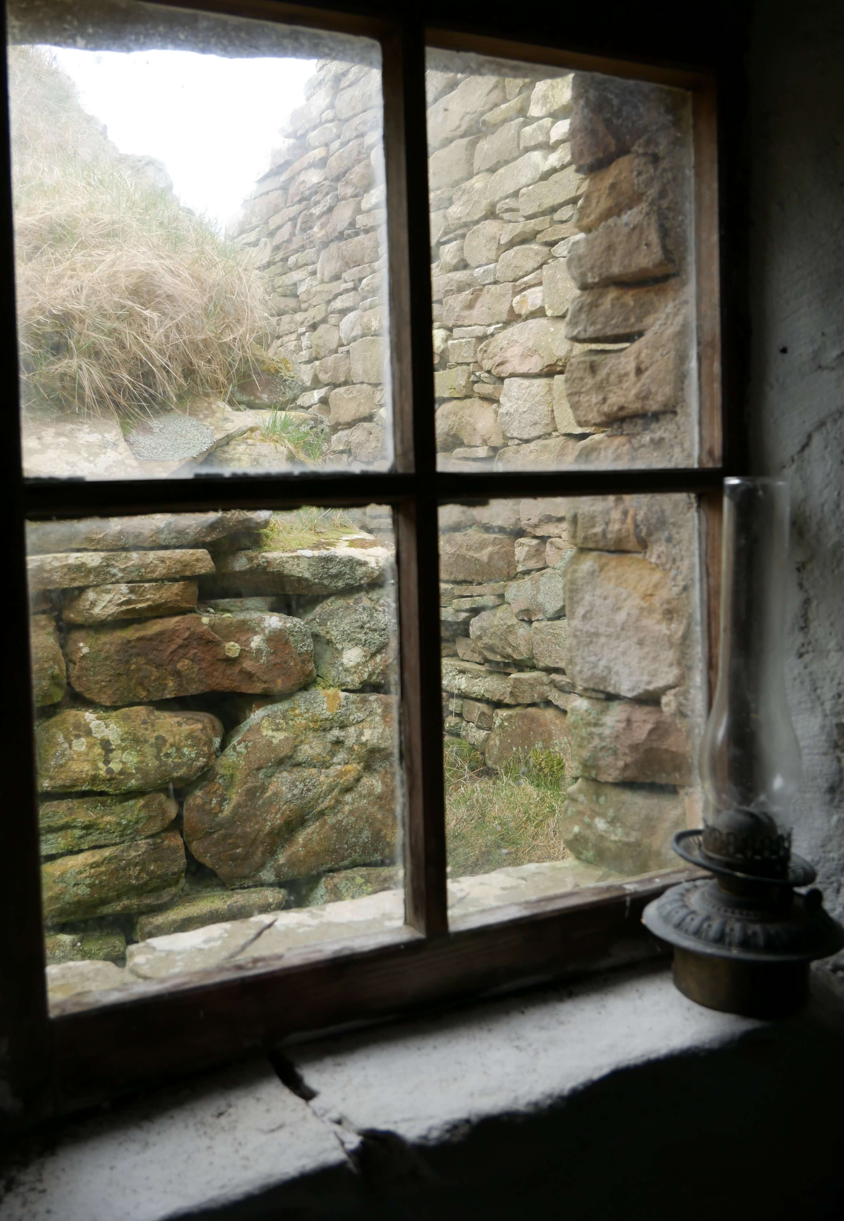 View through a window in one of the rustic Rackwick museums, Rackwick Bay, Hoy, Orkney Islands, Scotland, UK