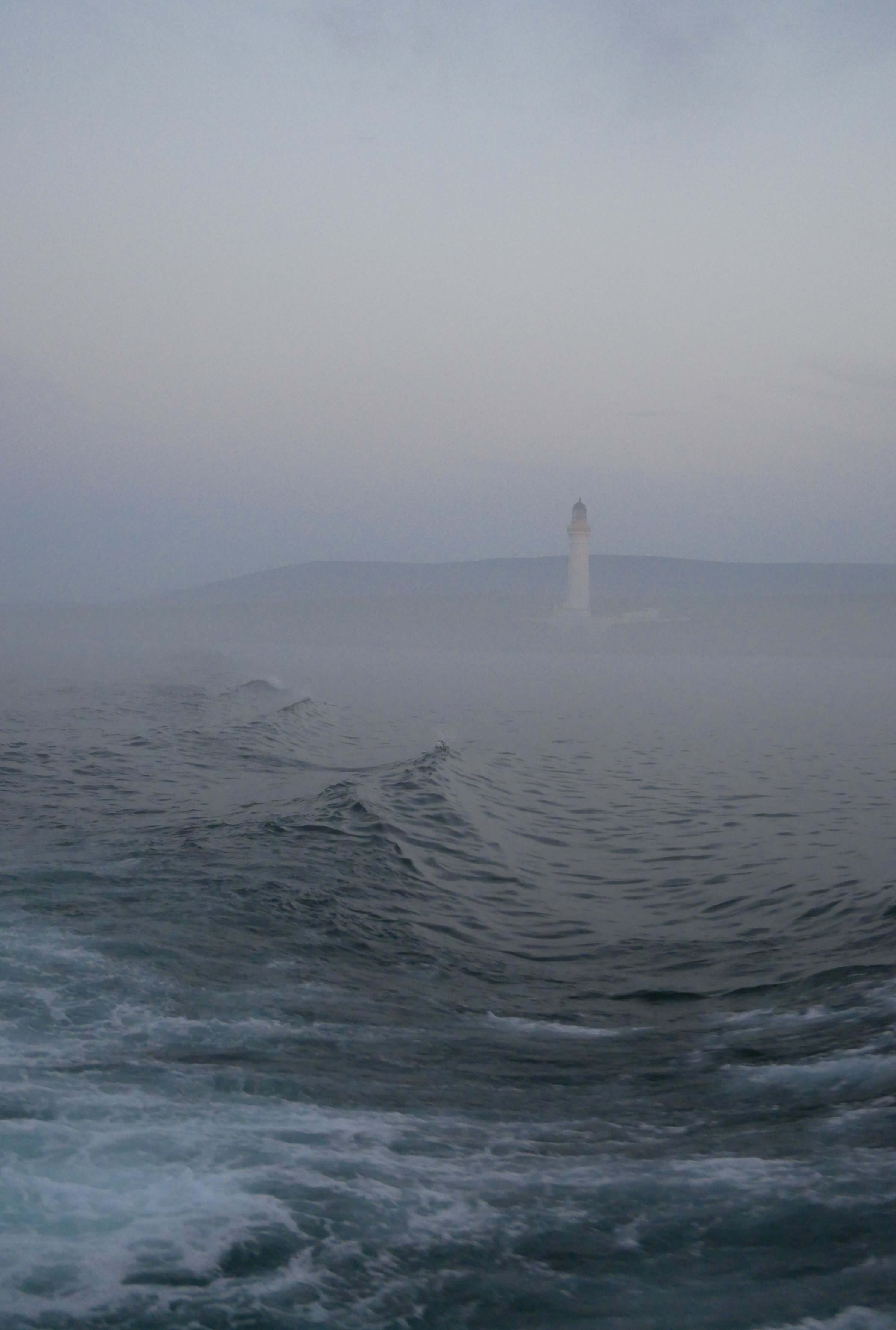 Hoy High lighthouse on the island of Graemsay, as seen from the ferry from Hoy to Stromness, Orkney Islands, Scotland.