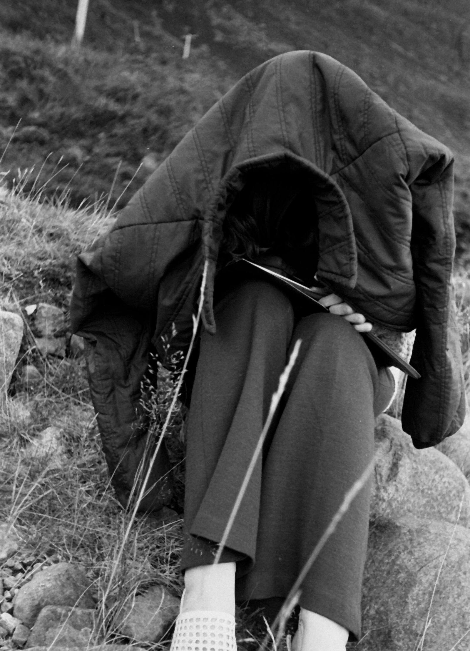 Woman hiding under a coat from midgies